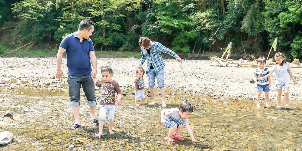 河原で遊ぶ家族の写真
