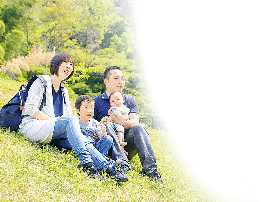 土手に座る四人家族の写真